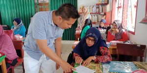 tim pengabdian Fahmil Haris, M.Pd. membantu peserta memahami pertanyaan pre test.