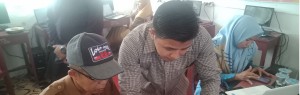 Tim pengabdian Windo Wiria Dinata, M.Pd membantu peserta mengaplikasikan program E-learning